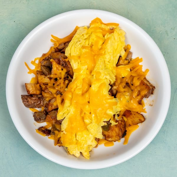 Ellen's Kitchen breakfast skillet with scrambled eggs, home fries, and melted cheddar cheese.
